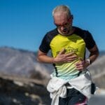 Jak poprawnie mierzyć tętno podczas biegu na WF i co ono mówi o kondycji Biegacz w okularach słonecznych na górskiej szosie w słoneczny dzień