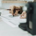 Jak napisać dobre opowiadanie na polski: plan, bohater i puenta w jednym poradniku Dłoń pisząca ołówkiem opowiadanie na kartce w naturalnym świetle