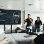 Angielski w pracy słownictwo i zwroty do spotkań maili i krótkich rozmów Dwójka współpracowników prowadzi prezentację biznesową po angielsku