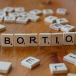 Różnice między moralnością a etyką na przykładach z życia Kostki Scrabble układające się w słowo abortion jako temat etyczny