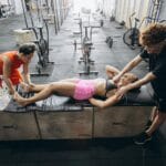 Jak dbać o regenerację po WF: sen, jedzenie, rozciąganie i rolowanie dla uczniów Zawodnicy podczas terapii regeneracyjnej bańkami i masażem w siłowni