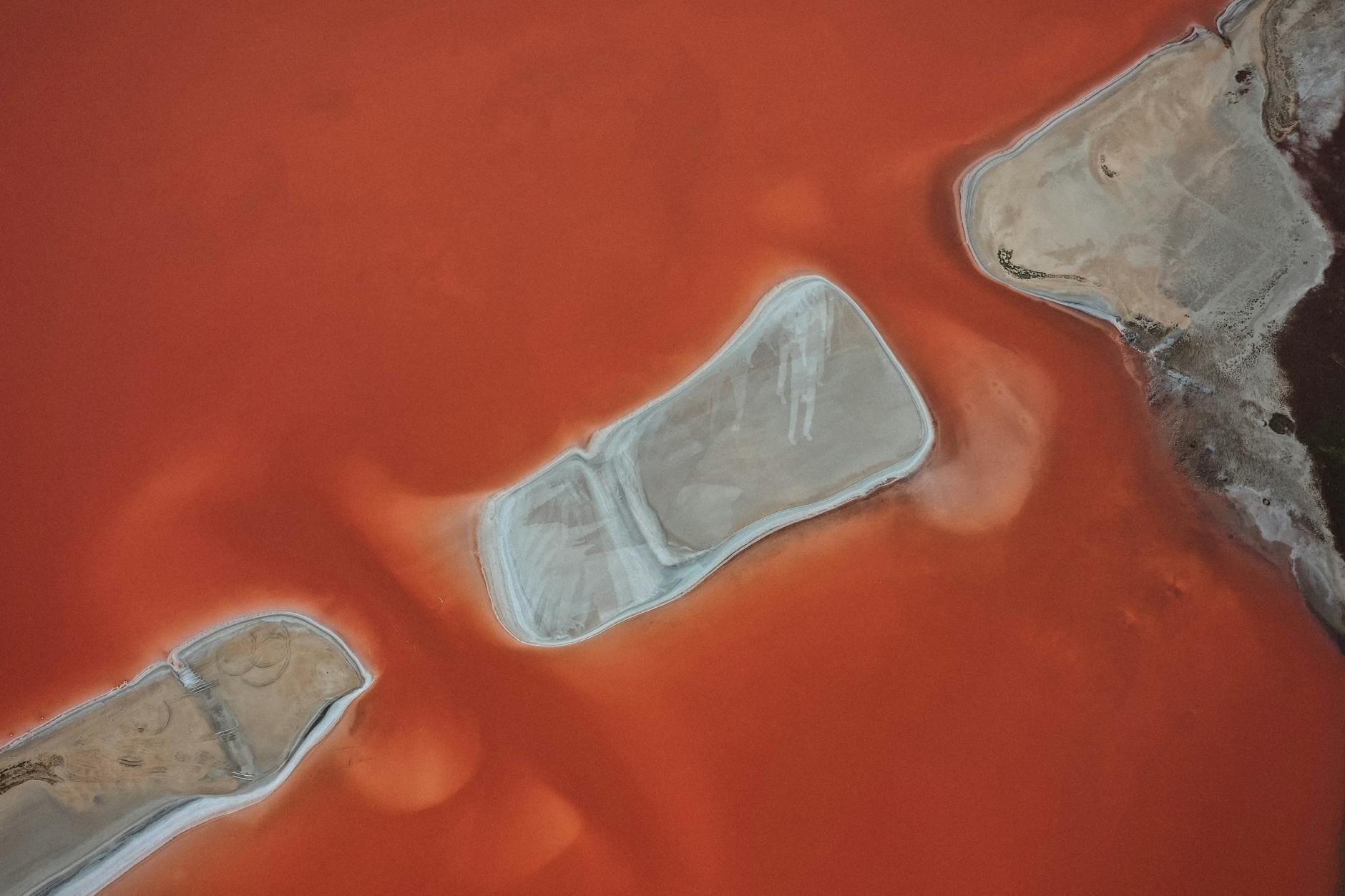 Czerwone słone jezioro z lotu ptaka z białymi solnymi formacjami