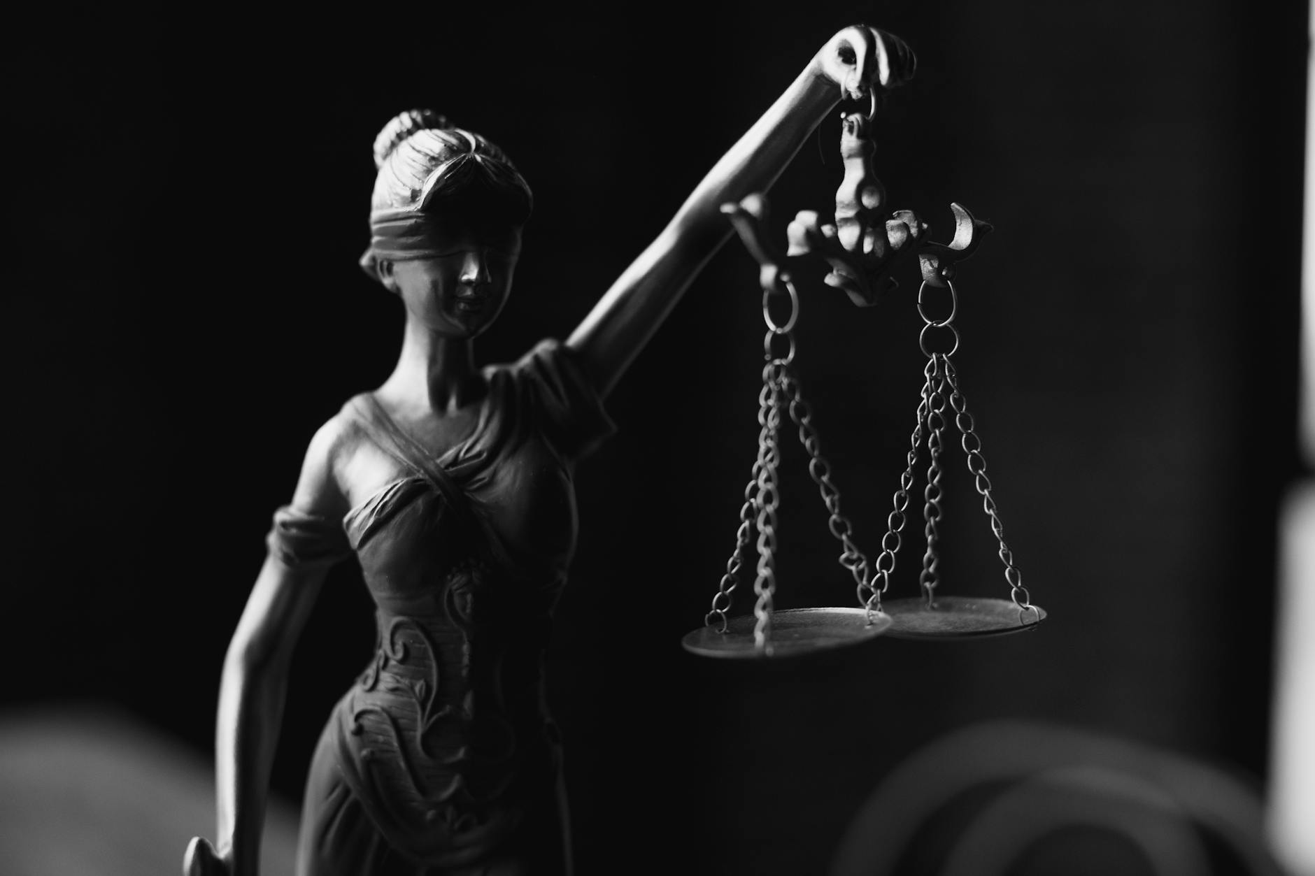 Czarno-biała figura Temidy z wagą w dłoni zbliżenie