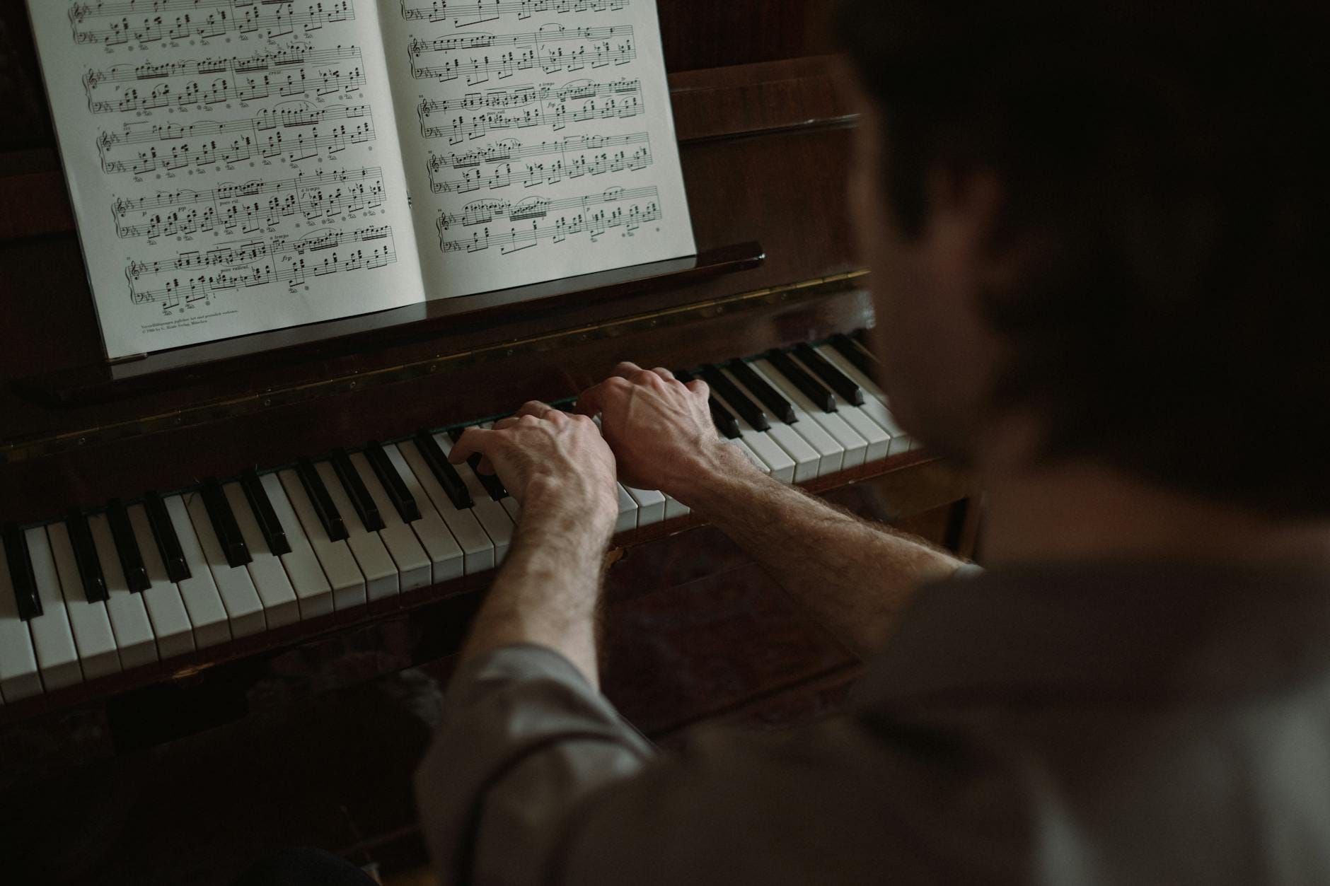 Pianista gra przy nutach ilustrujących zmianę tonacji utworu
