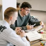 Dwóch młodych mężczyzn uczy się razem z książek do gramatyki