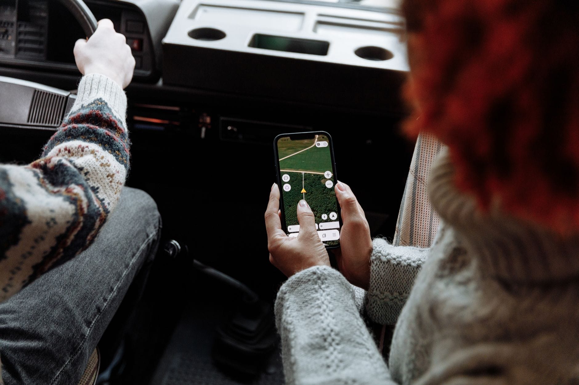 Dwie osoby korzystają z nawigacji GPS w smartfonie podczas podróży