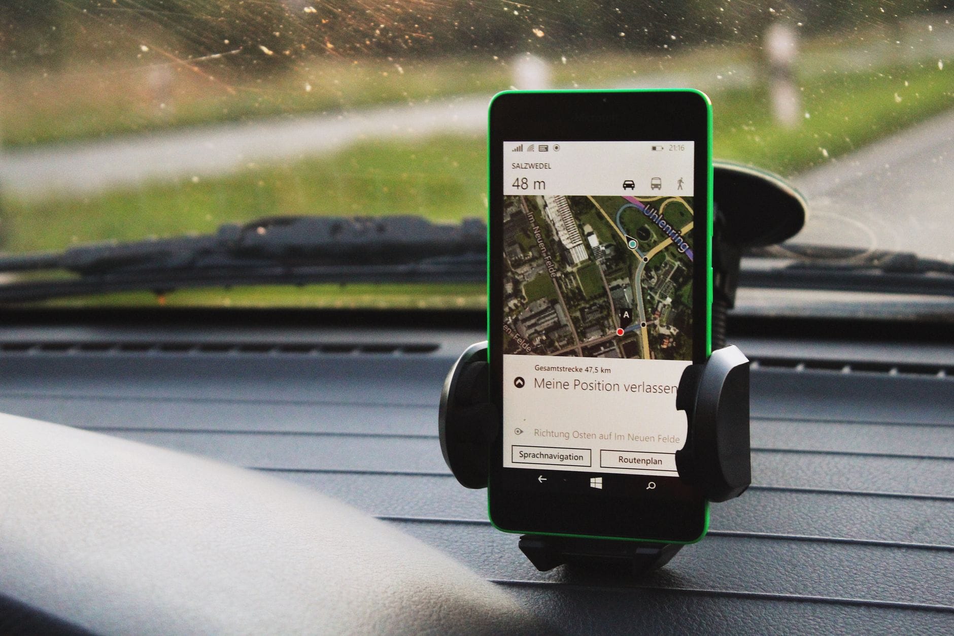 Smartfon z nawigacją GPS zamocowany na desce rozdzielczej auta